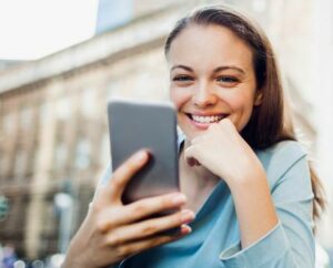 Close up of business woman using a phone while  drinking coffee