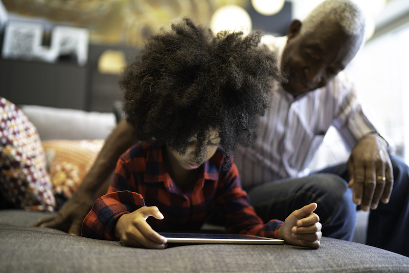 Grandfather and granddaughter playing with digital tablet